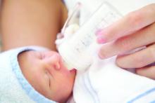 newborn baby drinks milk from a bottle